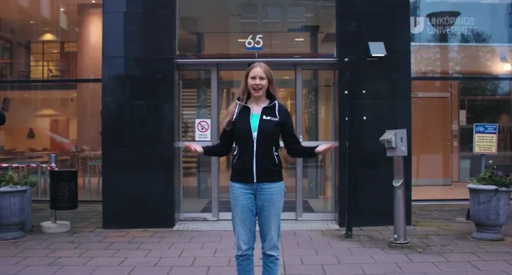 A student standing in front of the entrance to University Hospital Campus.