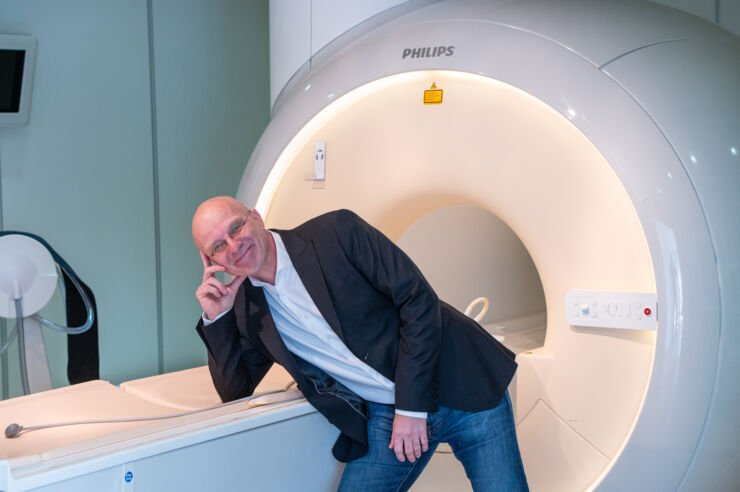 Man next to a magnetic resonance tomograph.