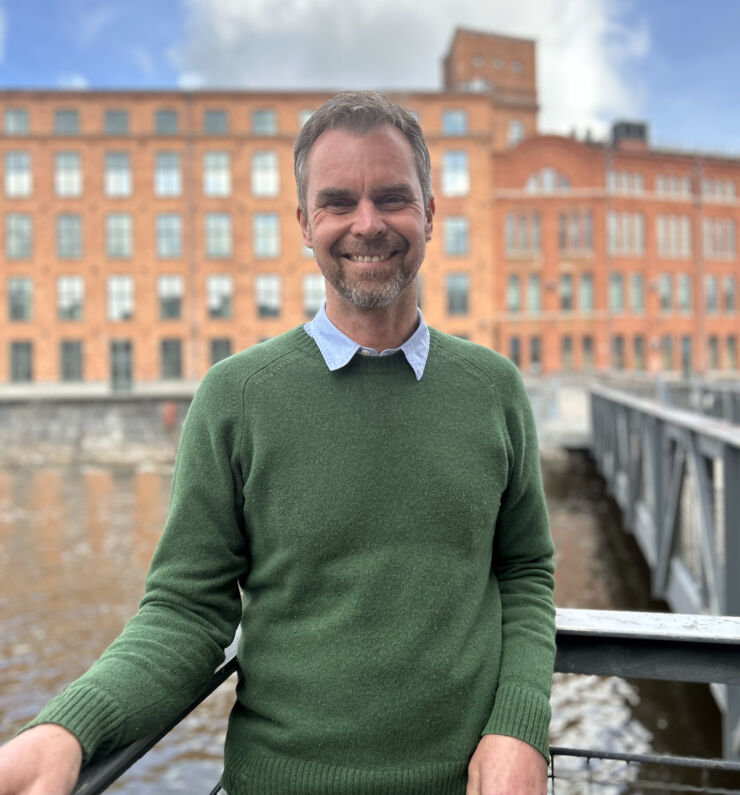 A man standing on a bridge crossing Motala Ström