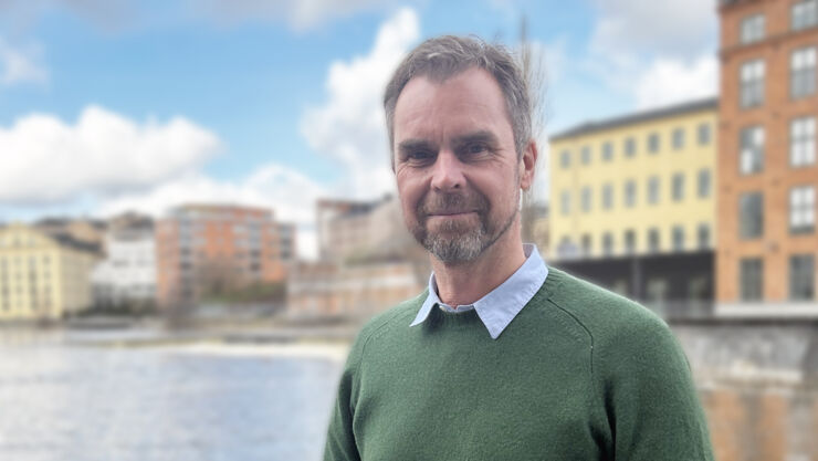 A man standing on a bridge crossing Motala Ström