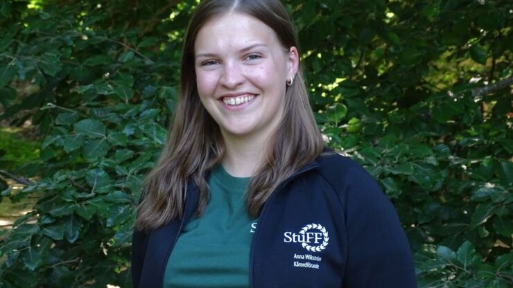 Portrait of a smiling Anna Wikström photographed outside in front of a tree