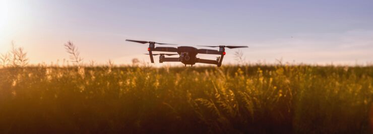 Drones flying over a well at sunset