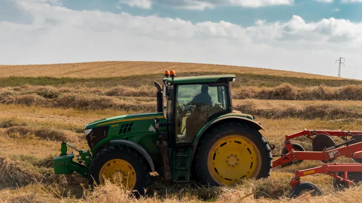 En John Deer traktor ute på fält.