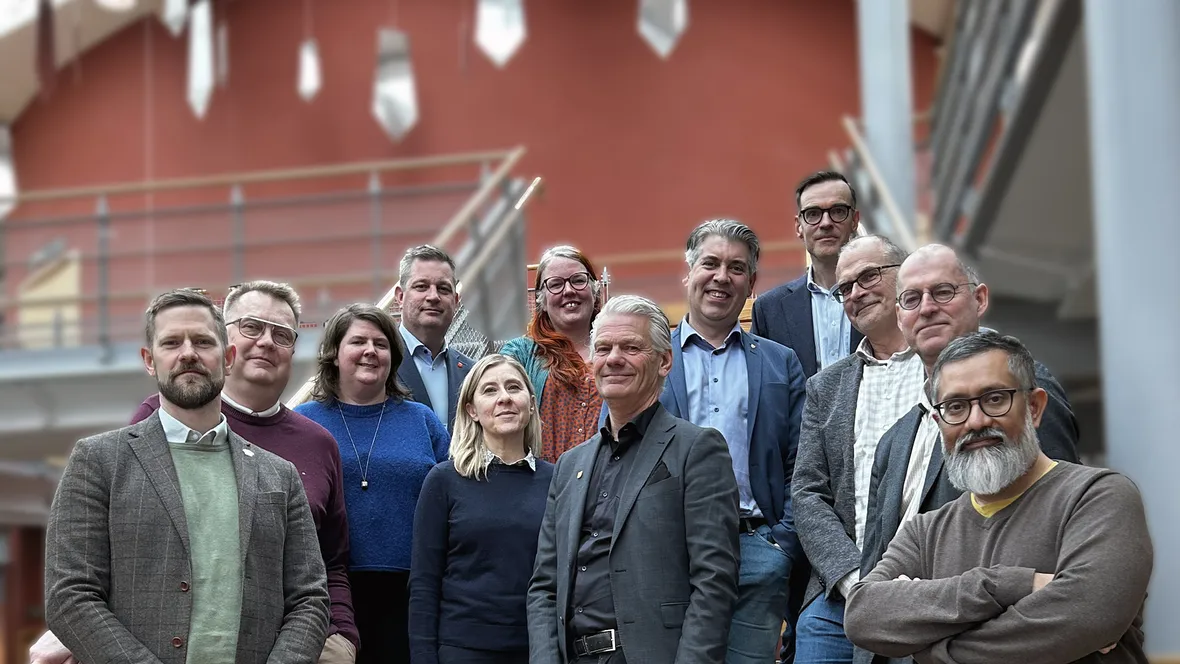 En grupp människor som står uppställda i en trappa inomhus