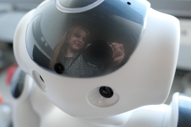 The photographer is reflected in the robot's shiny head