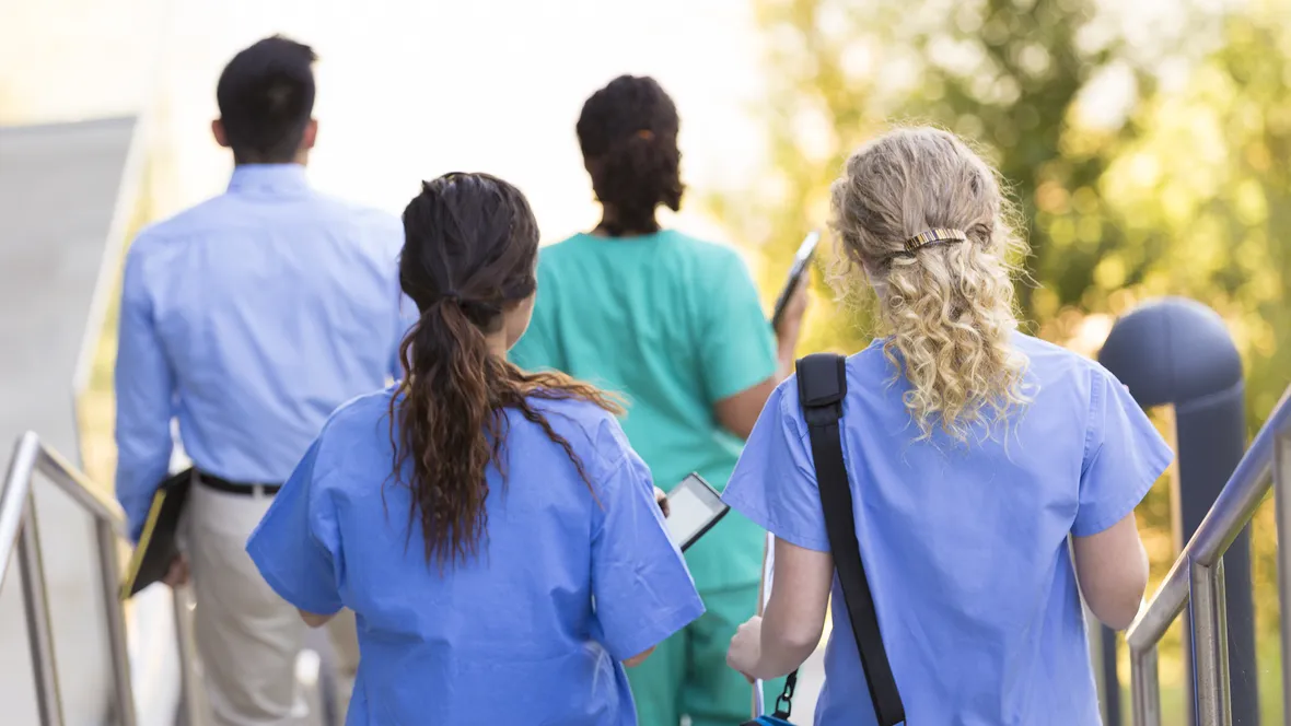 Vårdpersonal med ryggen vänd mot kameran.