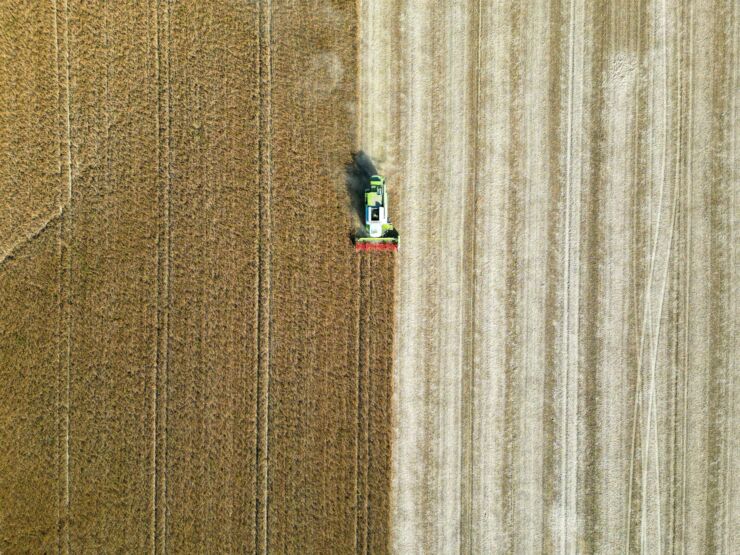 Drone image of a tractor that has harvested half a field.
