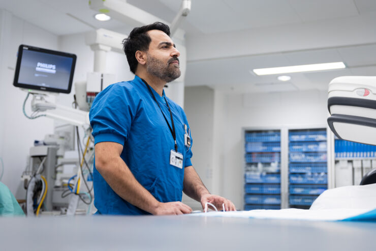 Male physician using equipment in a clinical setting.