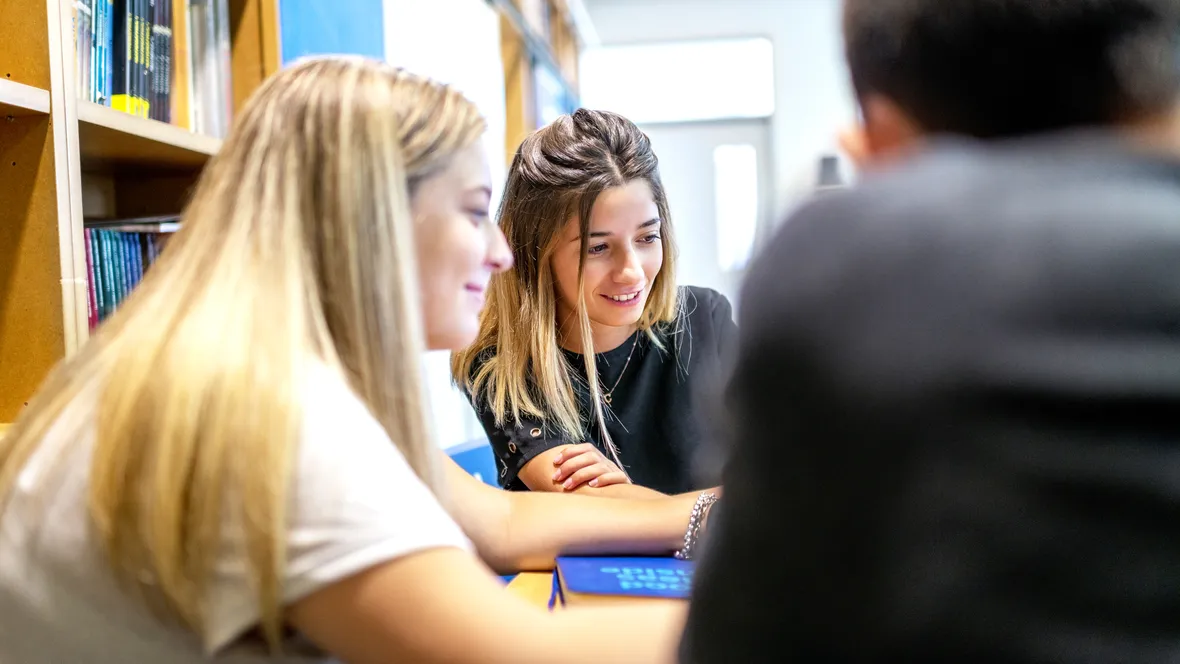 Elever diskuterar i bibliotek