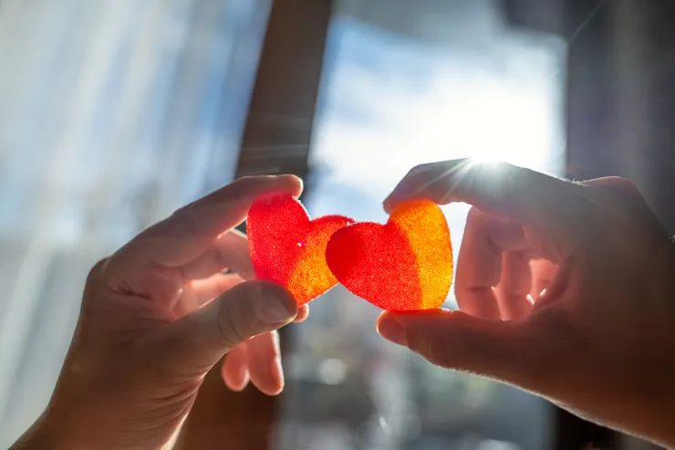 Hands holding candy in the shape of hearts