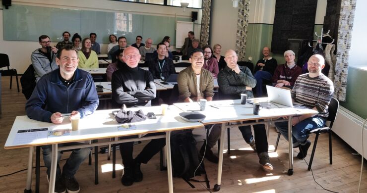 Group of people sitting in a room and looking straight ahead.