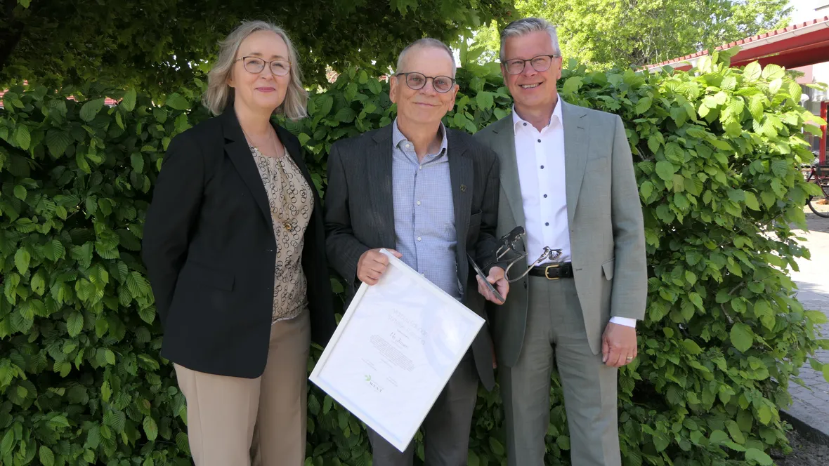 Forskare håller diplom med två personer från en stiftelse