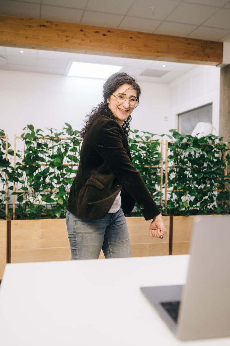 Person (Aseel Berglund) stands infront of a computer and hits the air.