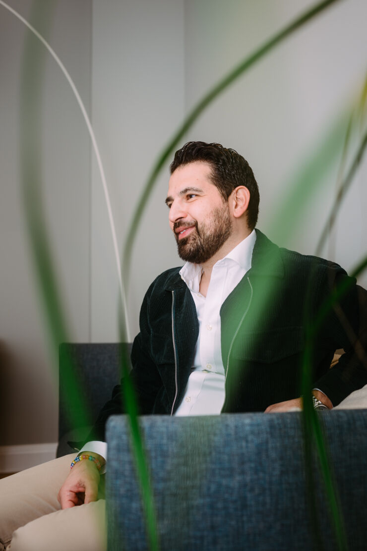 A man is seen behind a green plant