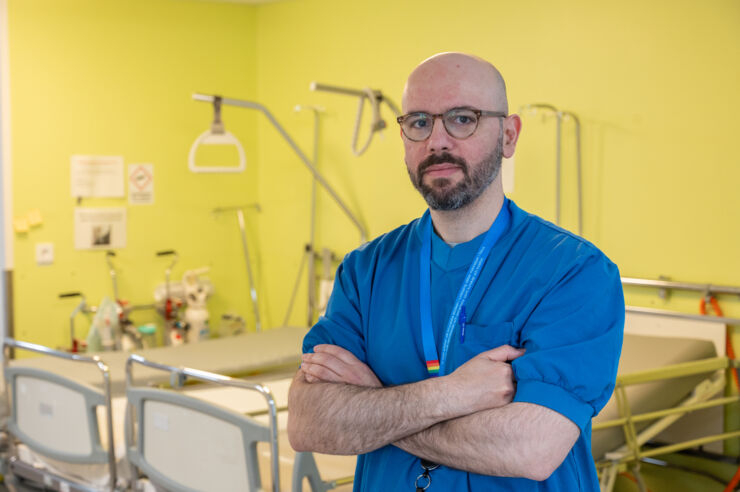 Portrait of man wearing blue hospital scrubs.