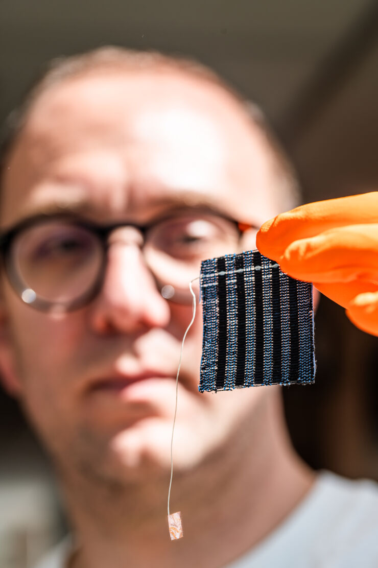 Researcher holds up a piece of cloth.