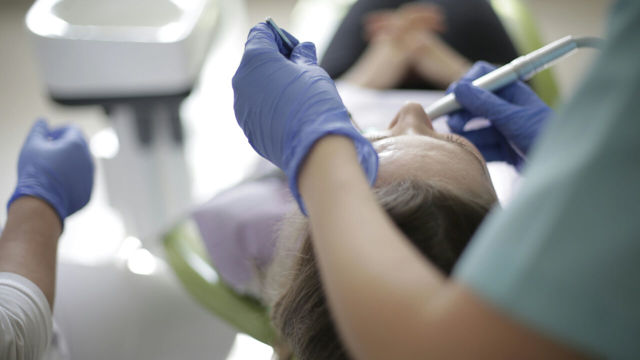 Tandläkare undersöker patient.