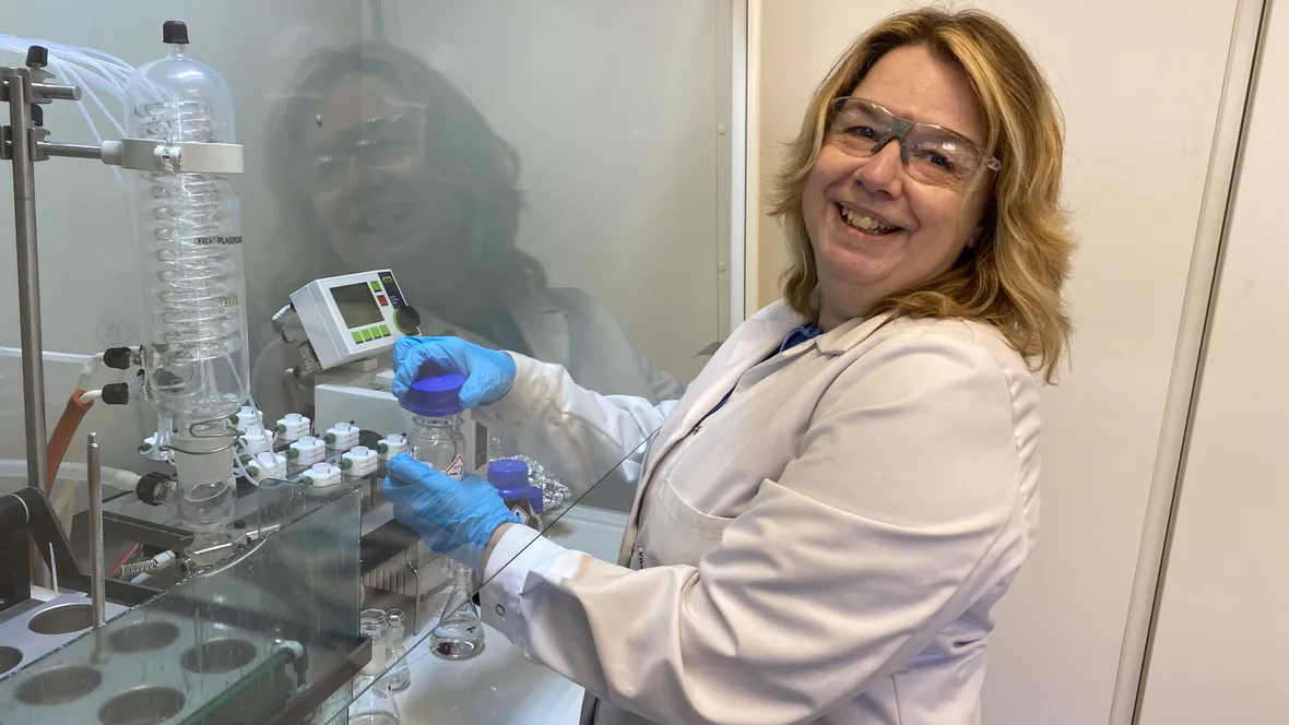 A woman in lab clothes in a lab.