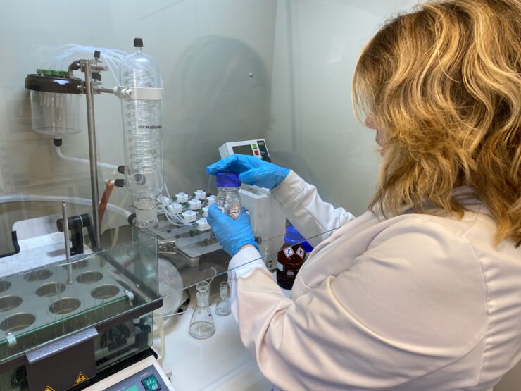 A woman with lab clothes working in a lab.