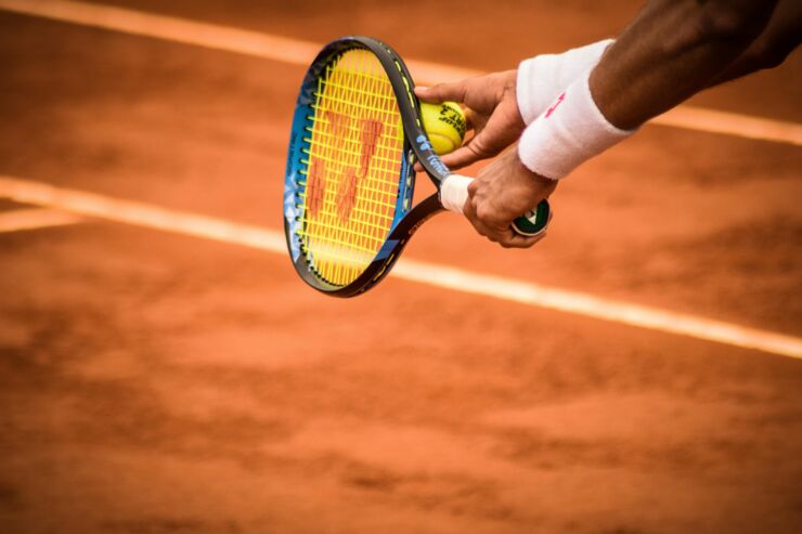 Tennisrack och en hand. 