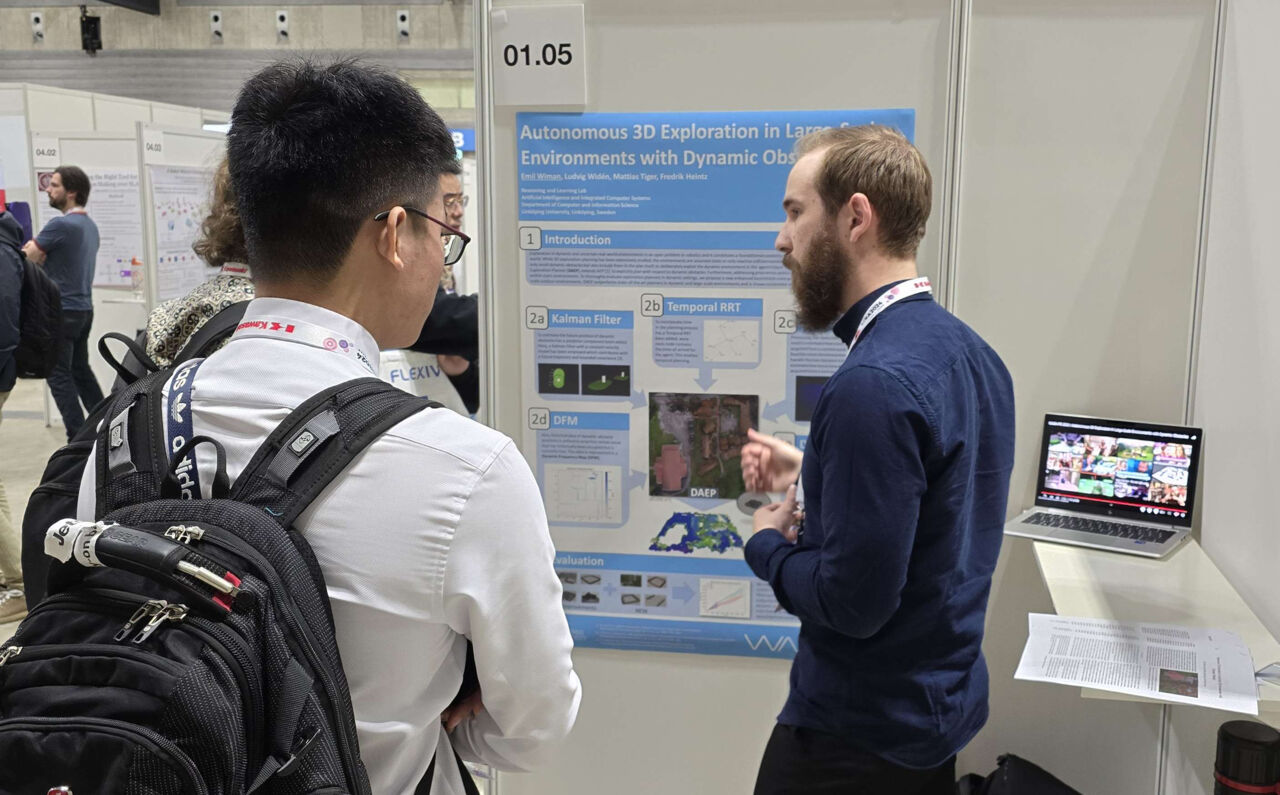 Män pratar framför en poster på en konferens