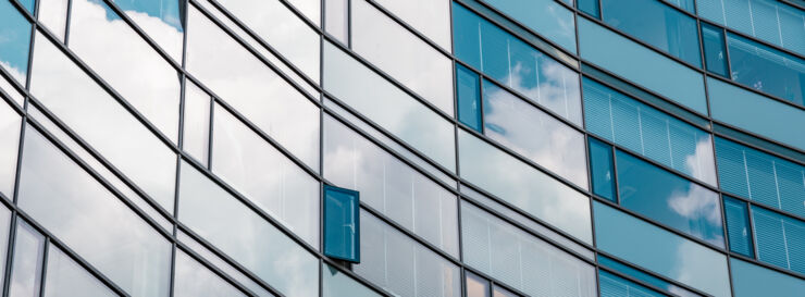 Rows of windows reflecting the sky. One window is open.