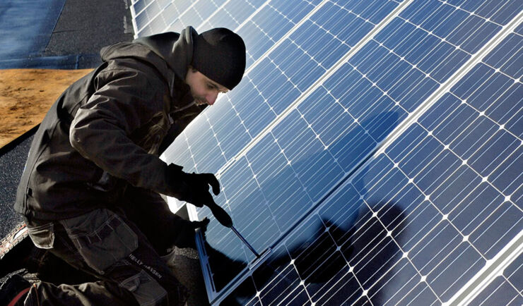 A men working with sun panel on roof.