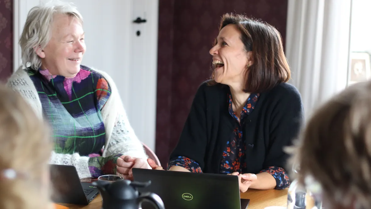 Två glada kvinnor i samtal.