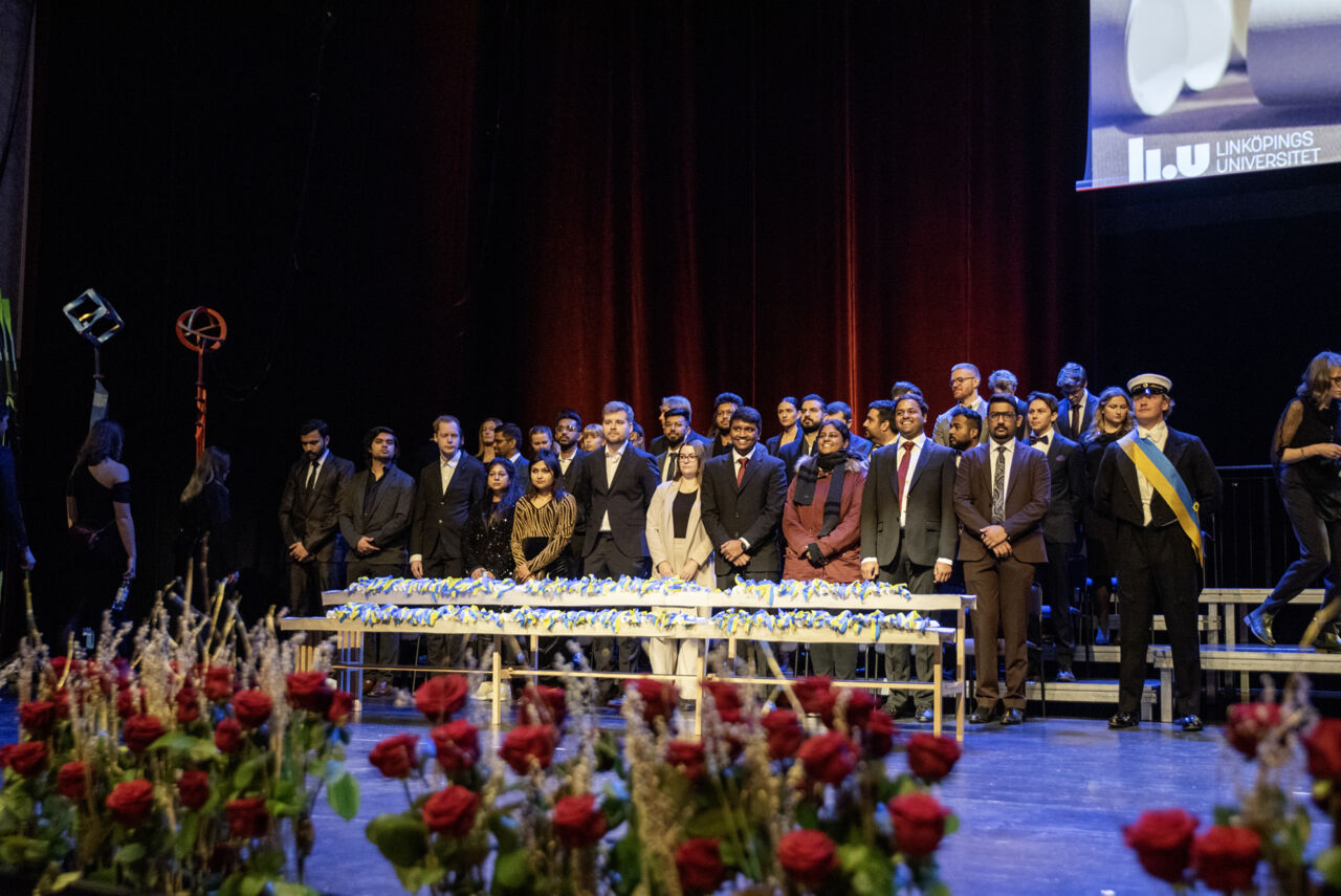 Bild på examinerade studenter som står på scen under examenshögtiden