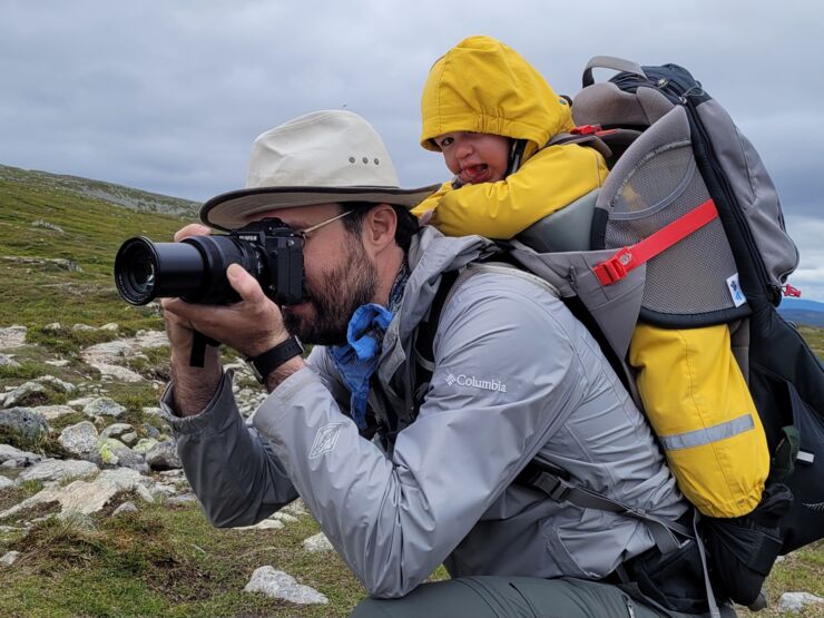 Antonios Pantazis photographing in a raincoat.