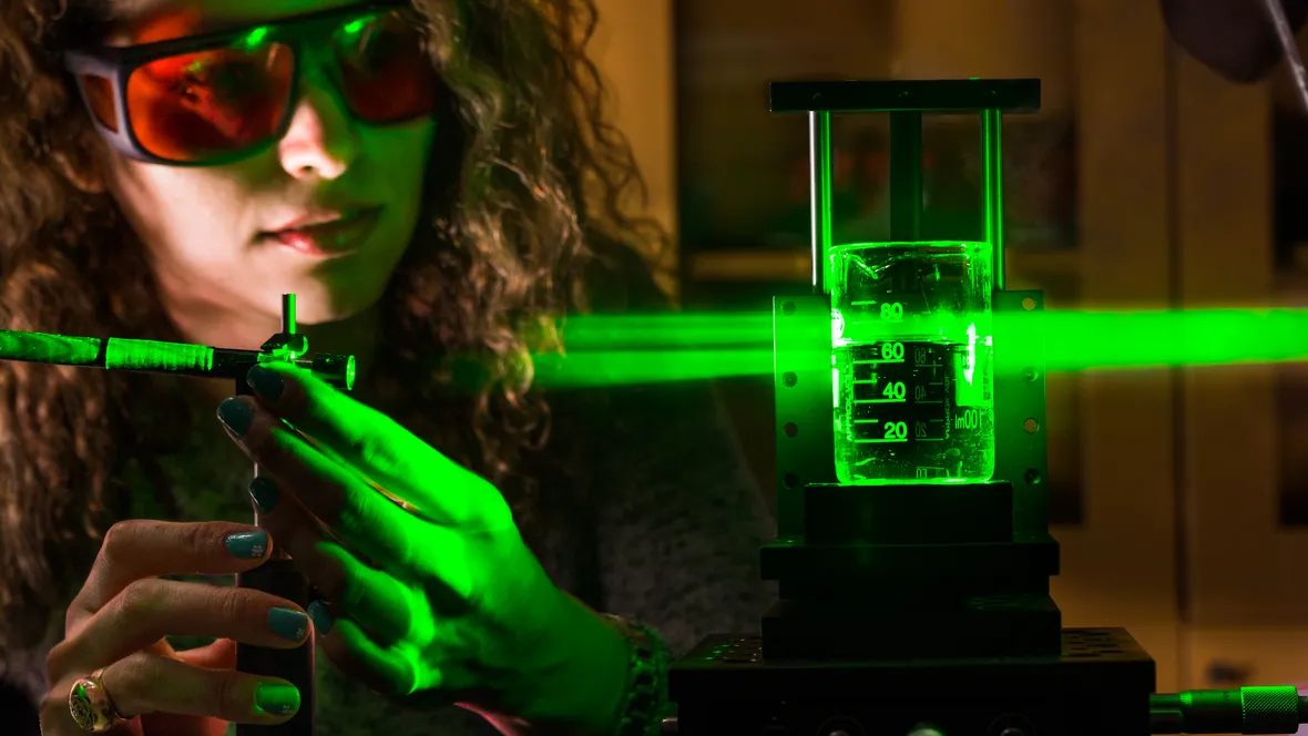 En kvinna experimenterar med grön laser