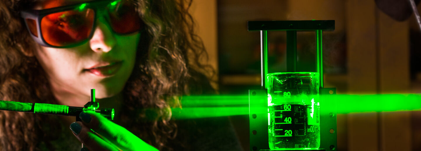A woman experimenting with green laser