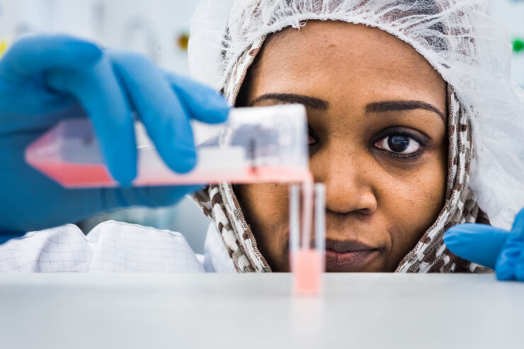 Closeup of a woman pouring a chemical into a test tube