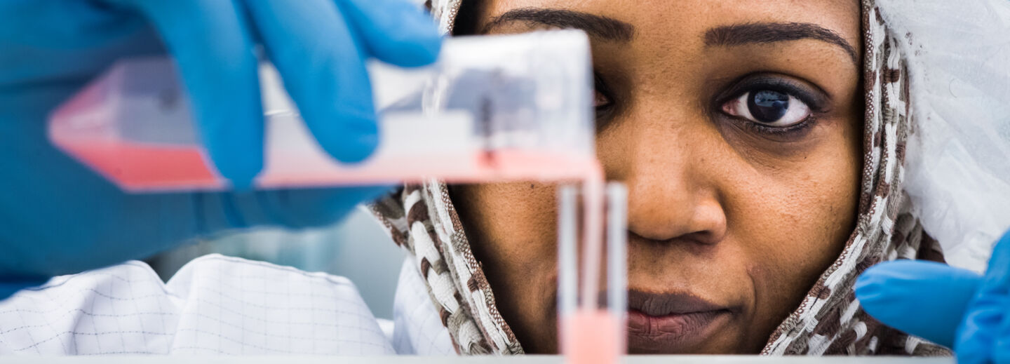 Closeup of a woman pouring a chemical into a test tube