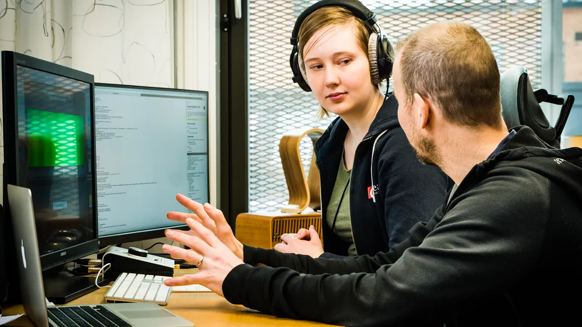 Student och lärare framför datorskärmar