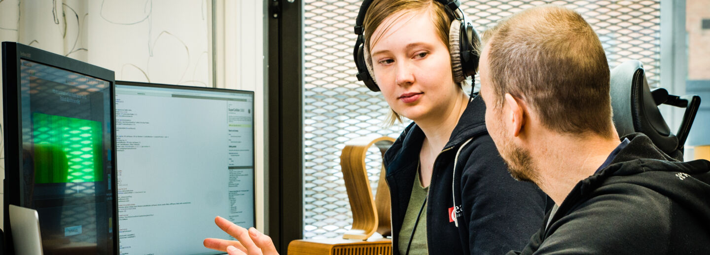 Student and teacher in front of computer screens
