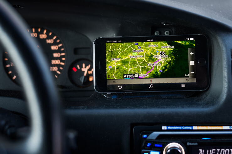 Cellphone with map view next to the steering wheel of a car