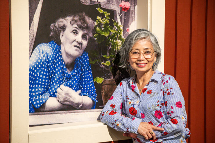 Neferti X. M. Tadiar infront of a photo of Moa Martinson inside Norrköpings Stadsmuseum.