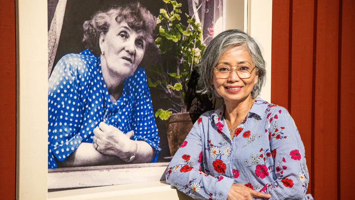 Neferti X. M. Tadiar framför ett foto av Moa Martinson inne på Norrköpings Stadsmuseum.