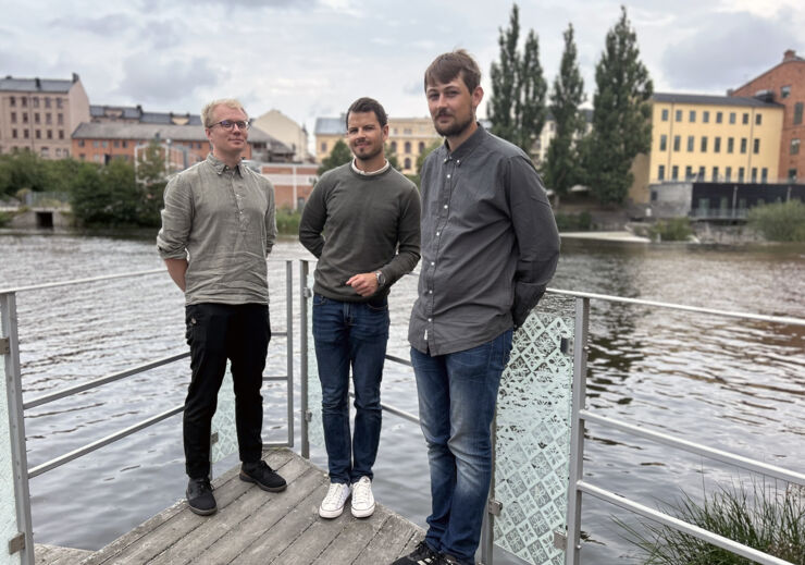 Tre studenter som står på en brygga vid Motala Ström