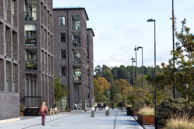 Människor som går och cyklar på framför ett våningshus