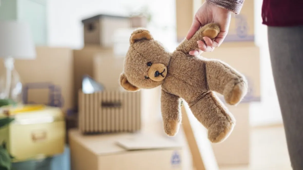 Barnhand håller i en nalle