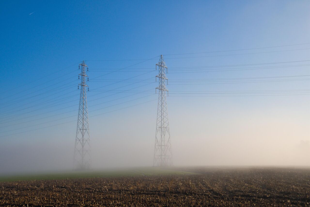 Powerlines at foggy field. 