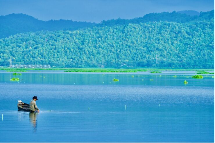 A fisherman in a boat in a lake