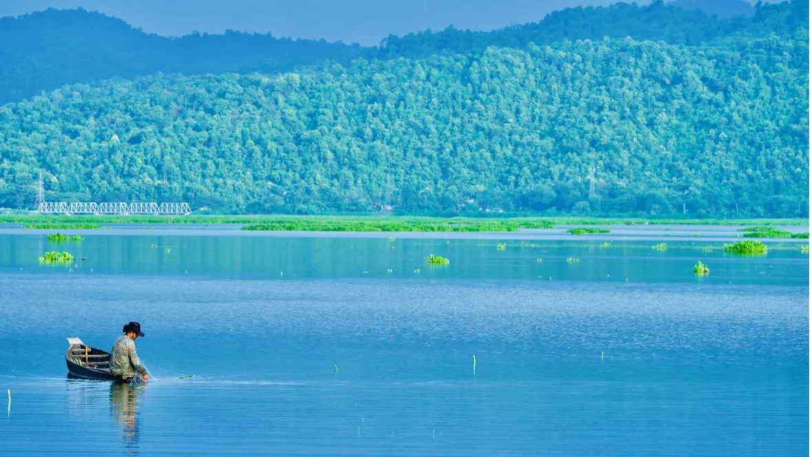 A fisherman in a boat in a lake