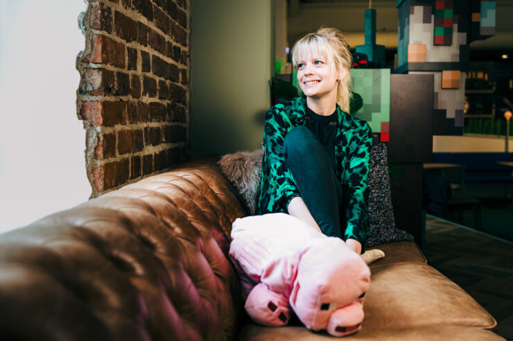 Person (Agnes Larsson) sitting in a couch with a teddy pig.