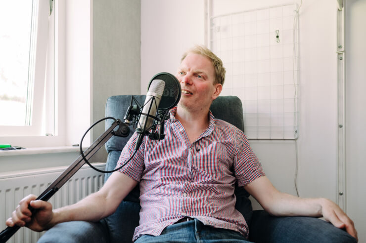 A person next to a podcast microphone.