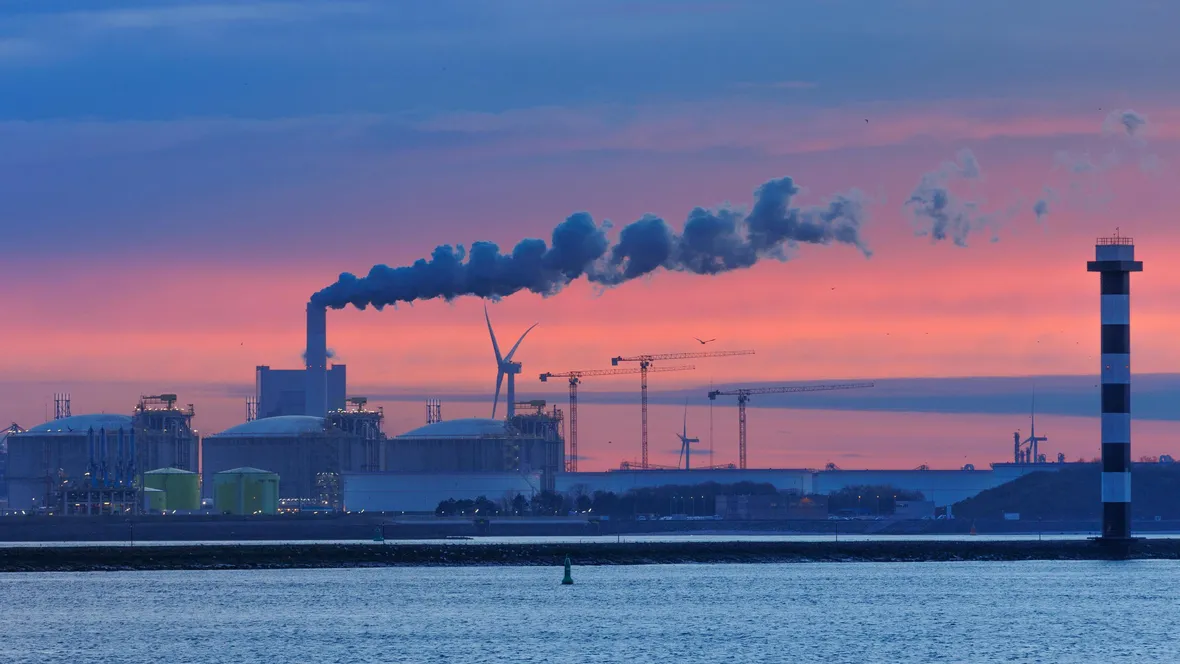 Industri vid vattnet under blå och rosa himmel