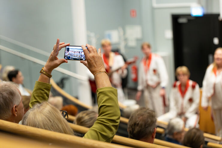 Person fotograferar uppträdande med sin mobil