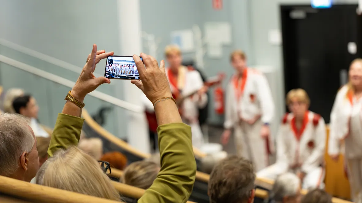 Person fotograferar uppträdande med sin mobil